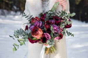 Lavender and dark red Wedding bouquet in hands of the bride